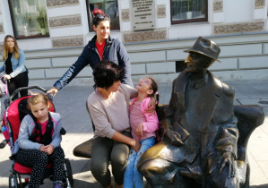 Dzieci siedzący na ławeczce obok pomnika Juliana Tuwima.